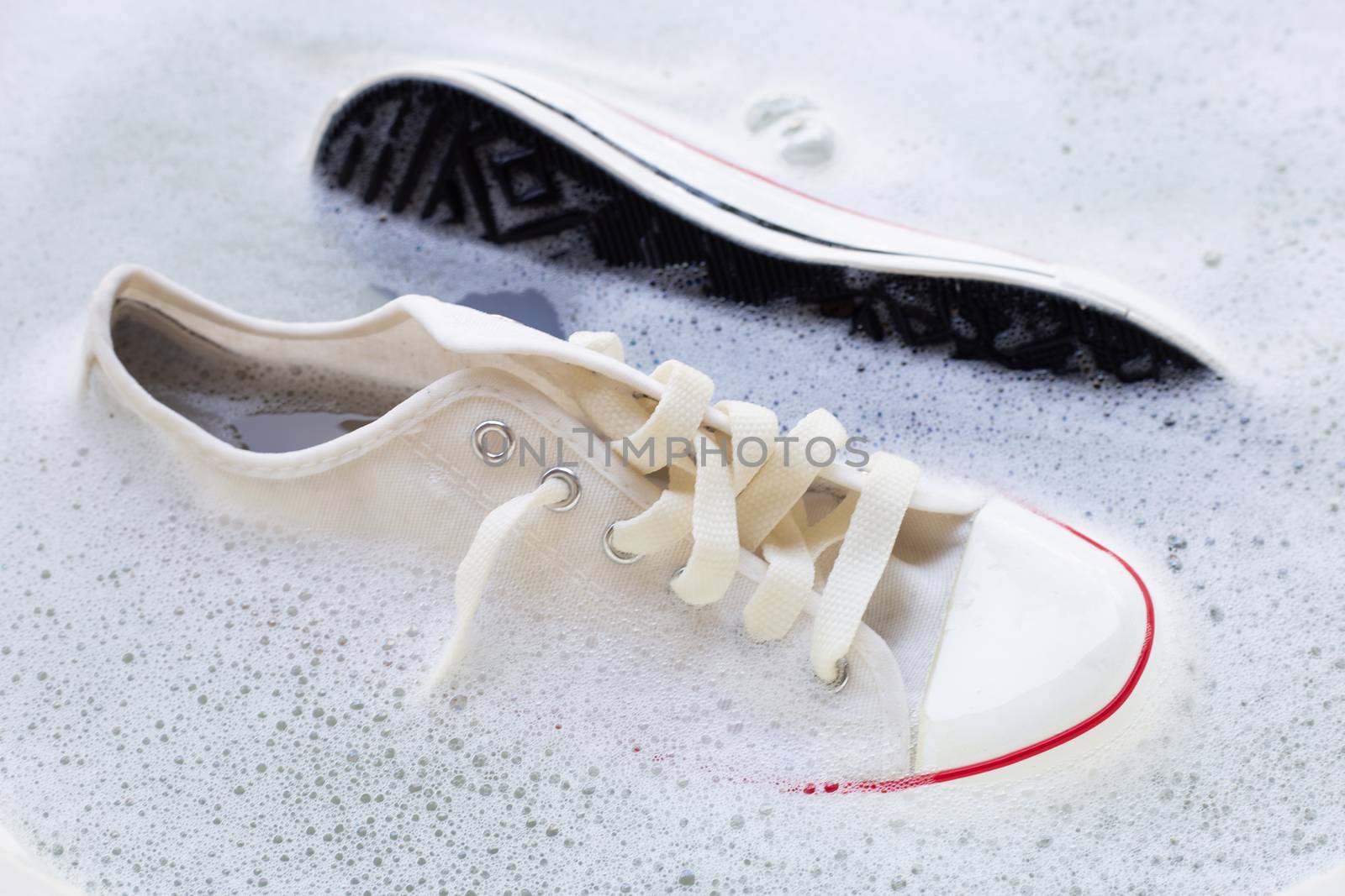 Soak shoes before washing. Dirty sneakers. by Bowonpat