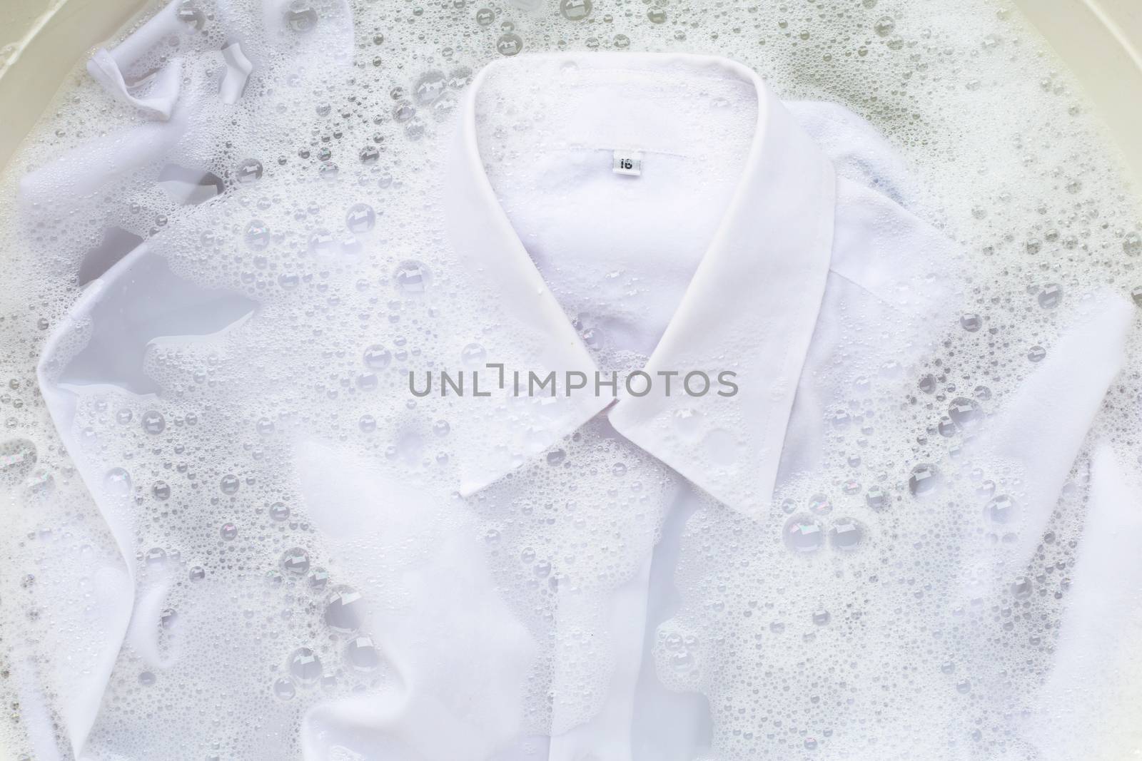 Soak  cloth before washing, white shirt by Bowonpat