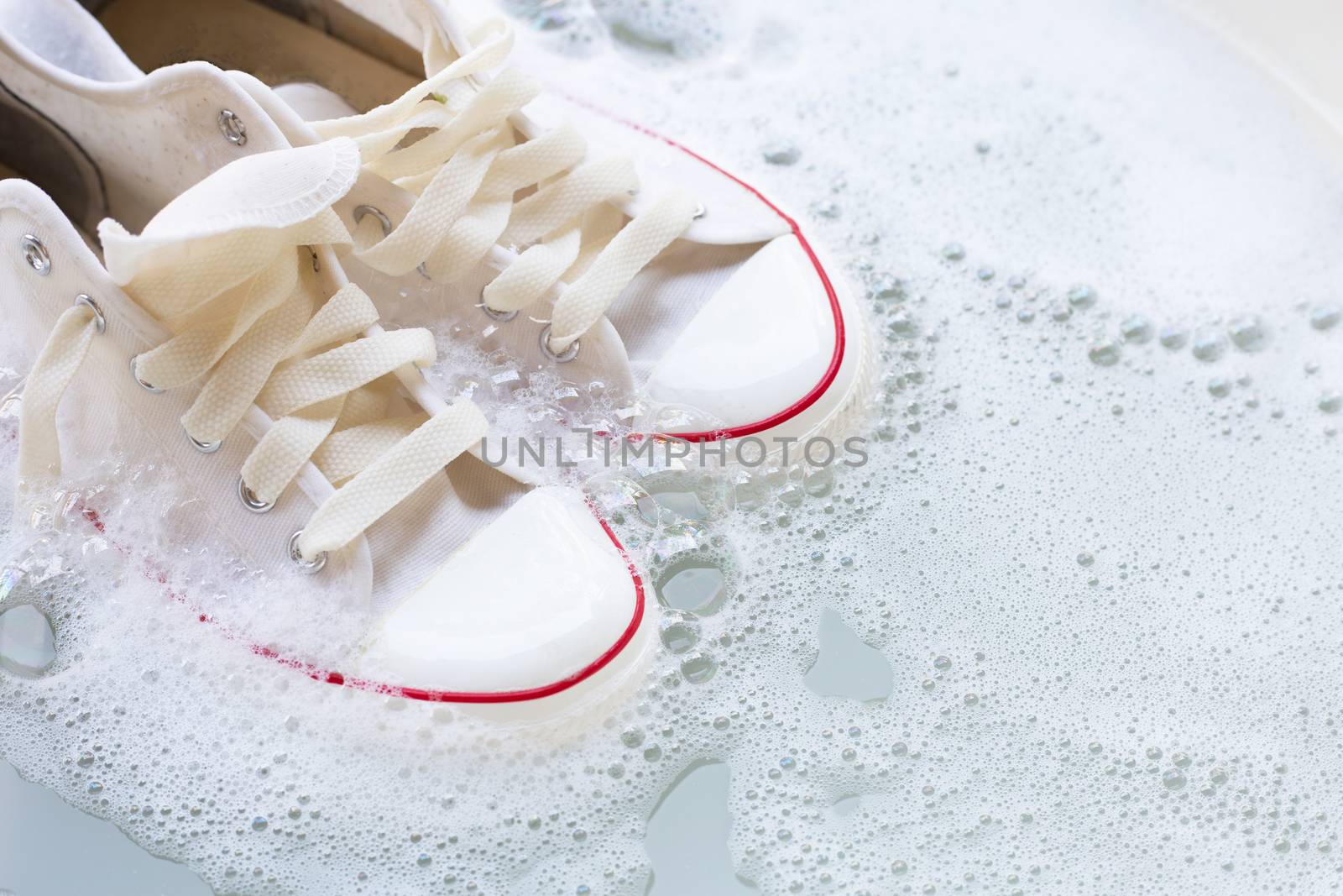 Soak shoes before washing. Dirty sneakers. by Bowonpat