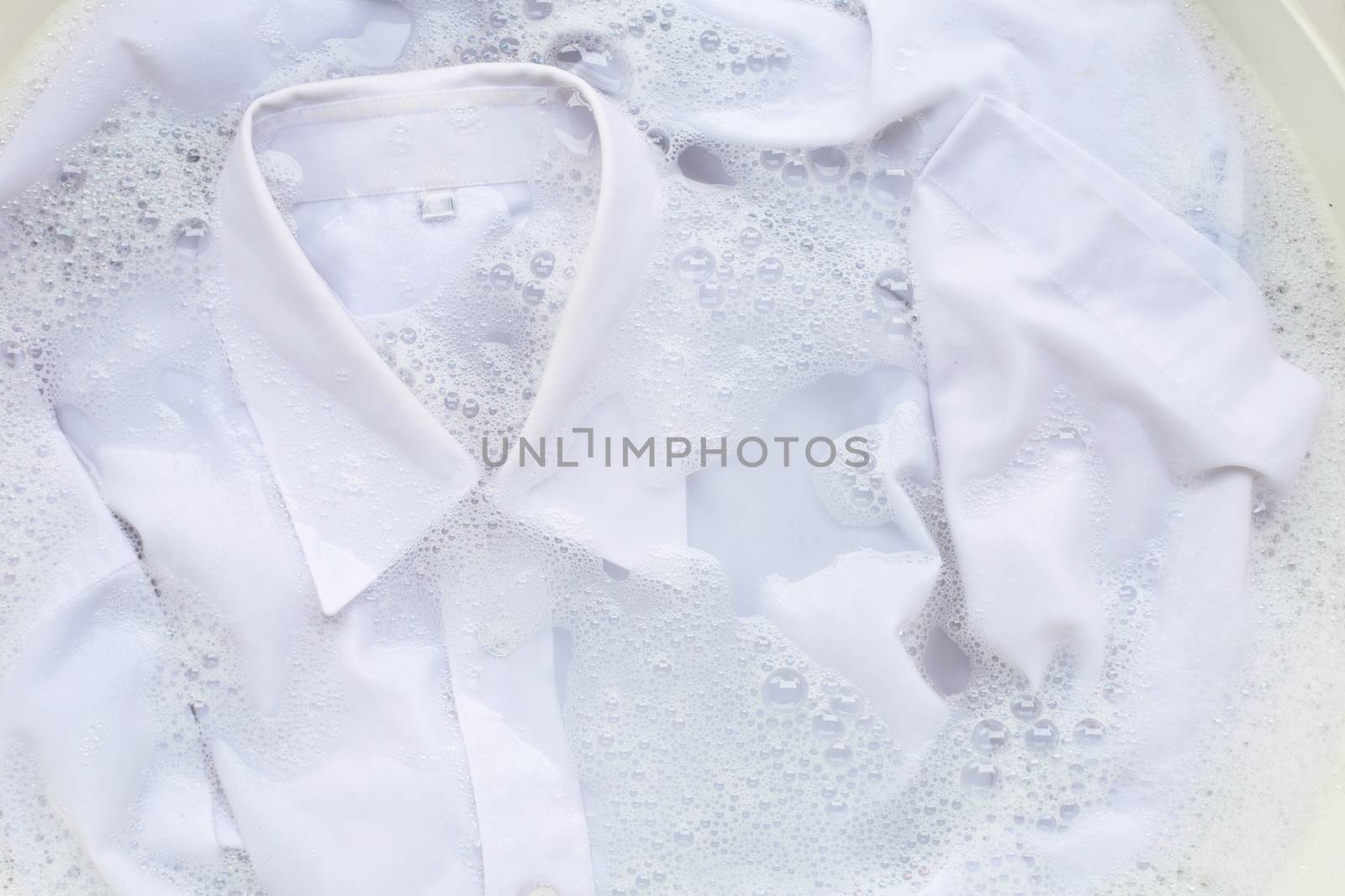 Soak  cloth before washing, white shirt by Bowonpat