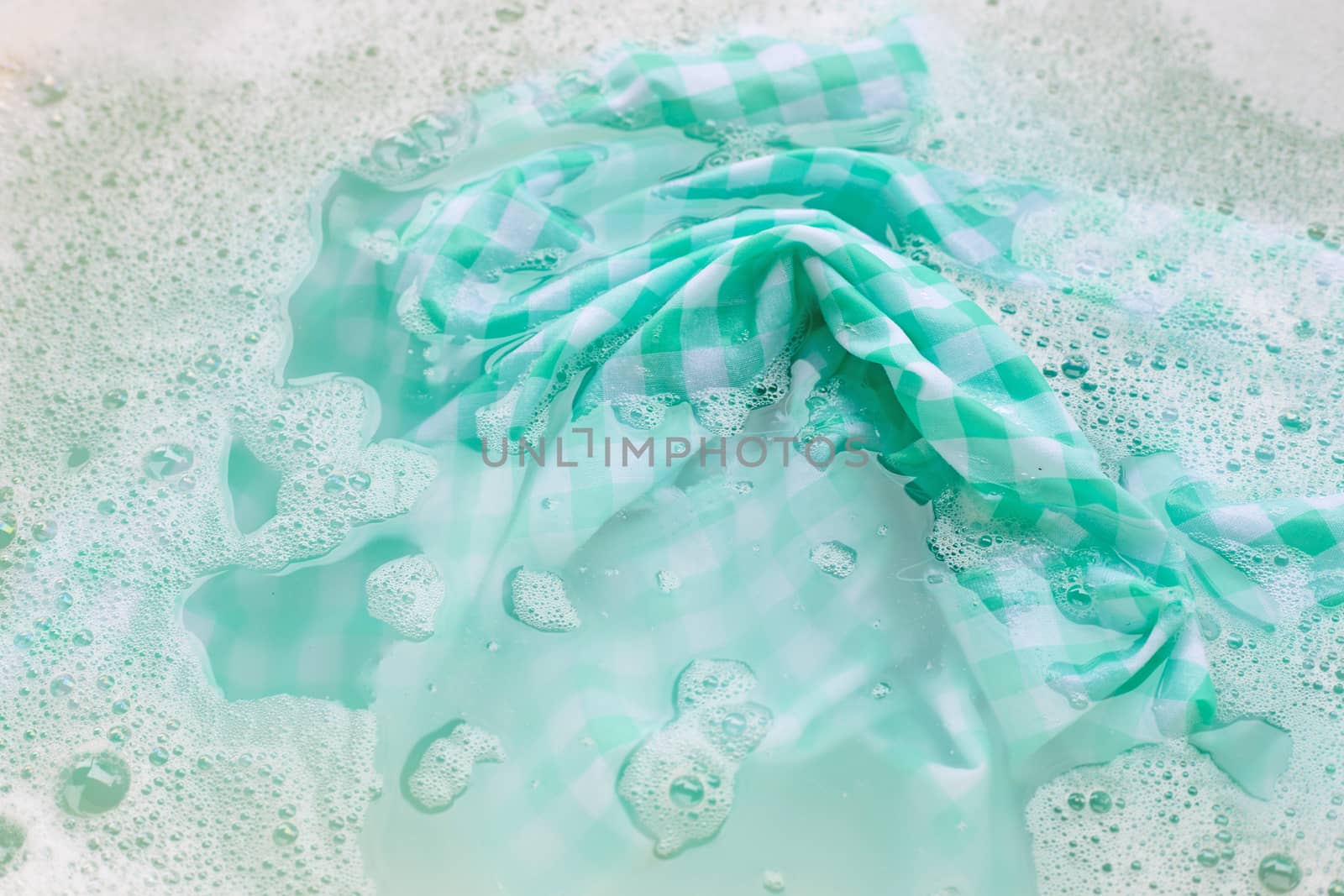 Soak green white tablecloth before washing by Bowonpat