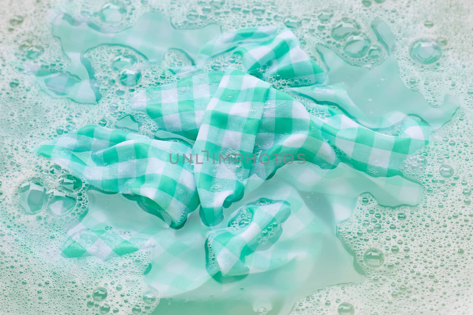 Soak green white tablecloth before washing. by Bowonpat