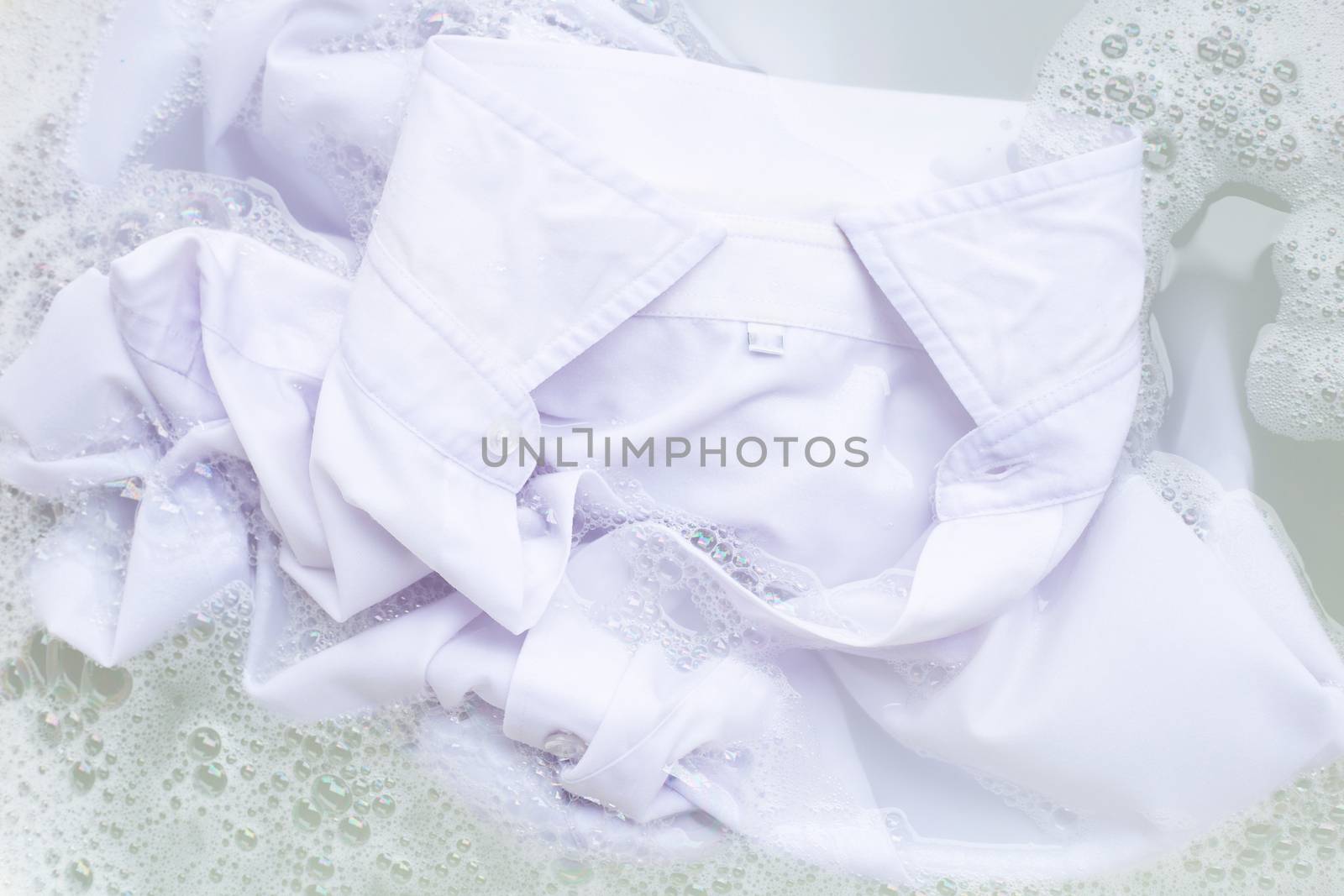 Soak  cloth before washing, white shirt by Bowonpat