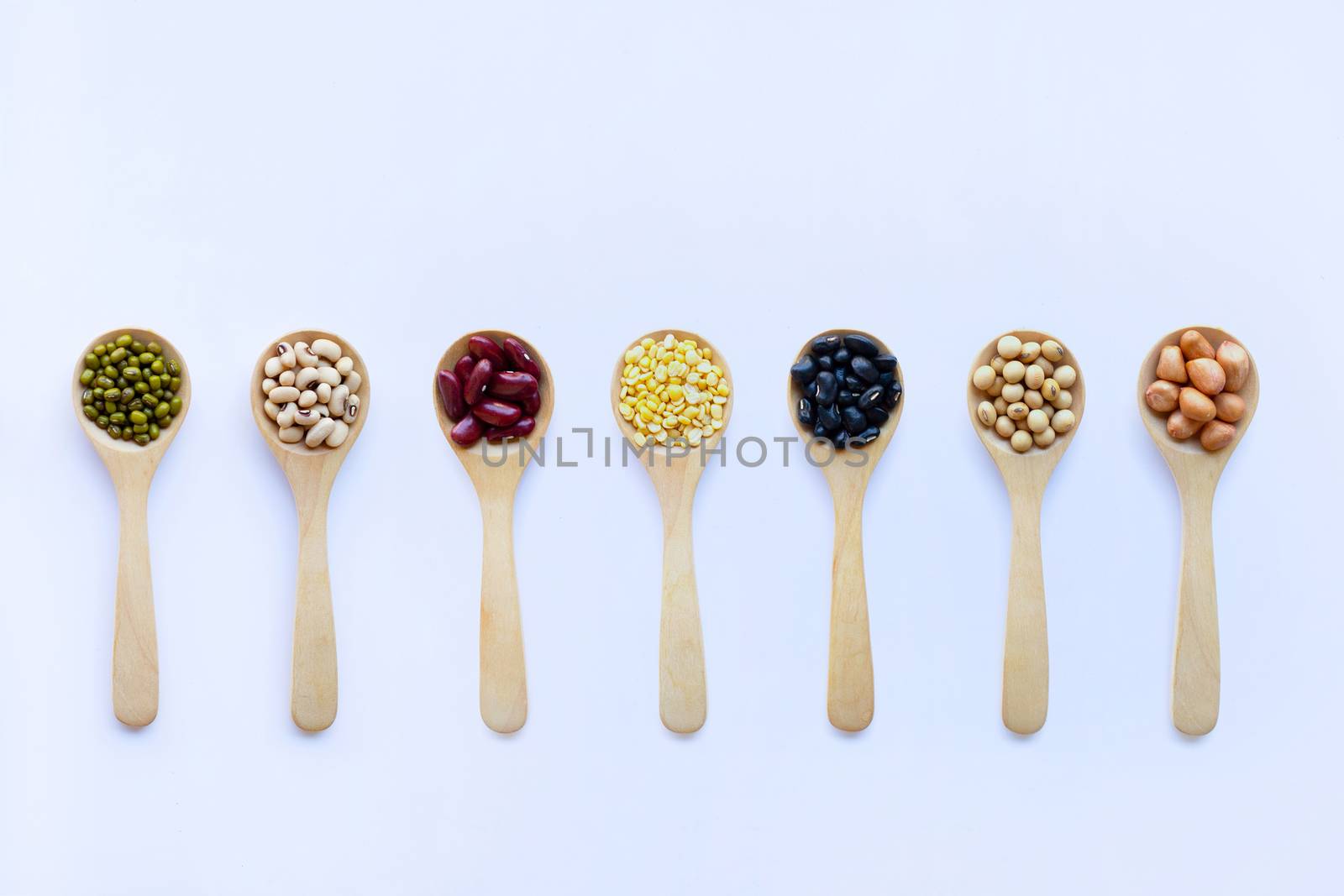 Different beans, legumes on wooden spoon  by Bowonpat