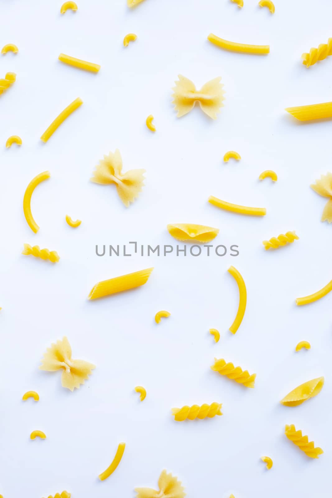 Different types of dry pasta on white background