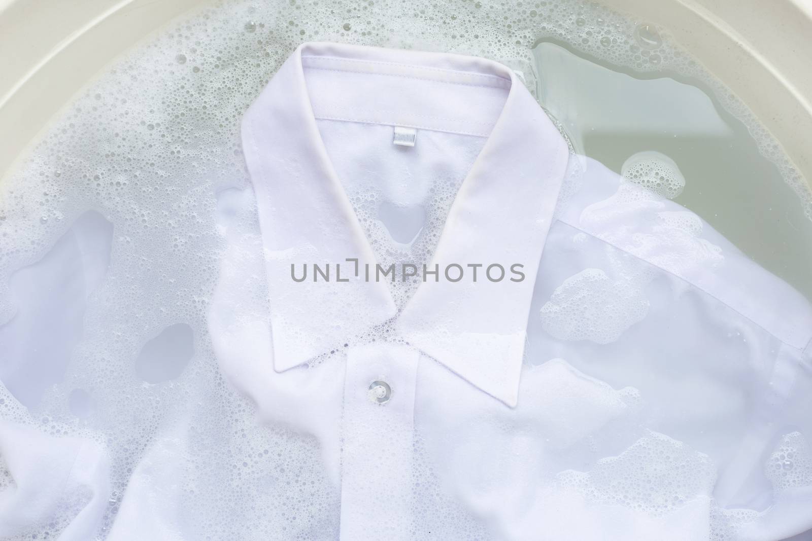 Soak  cloth before washing, white shirt by Bowonpat