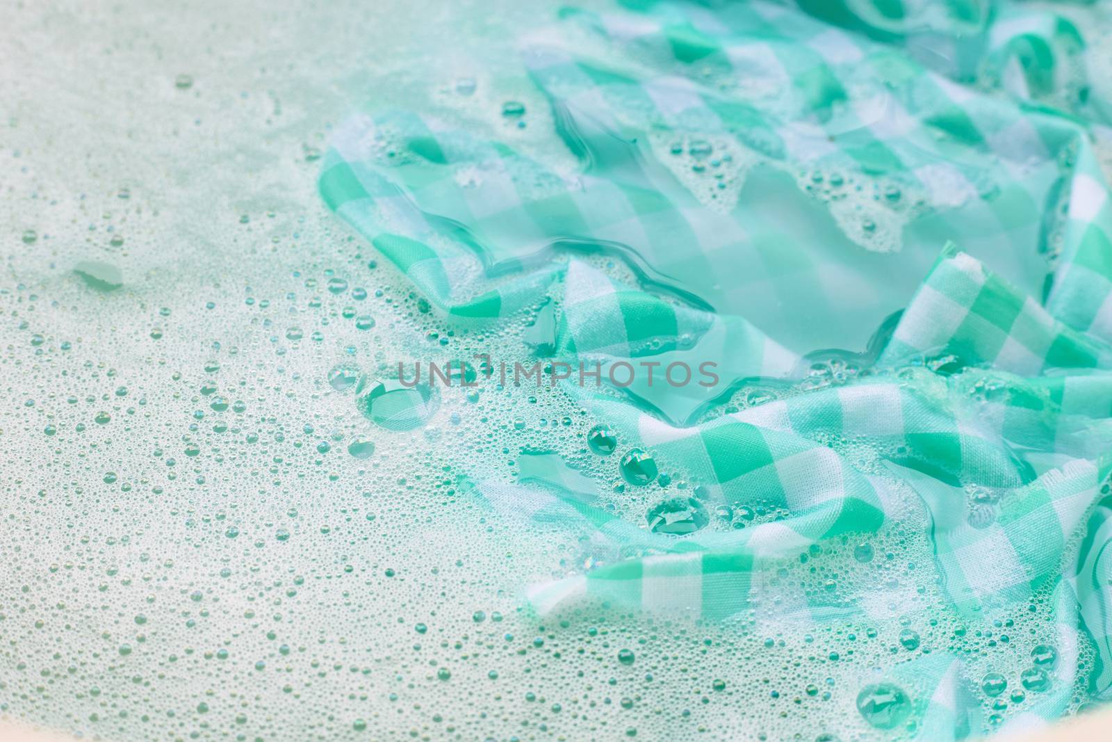 Soak  green white tablecloth before washing. by Bowonpat