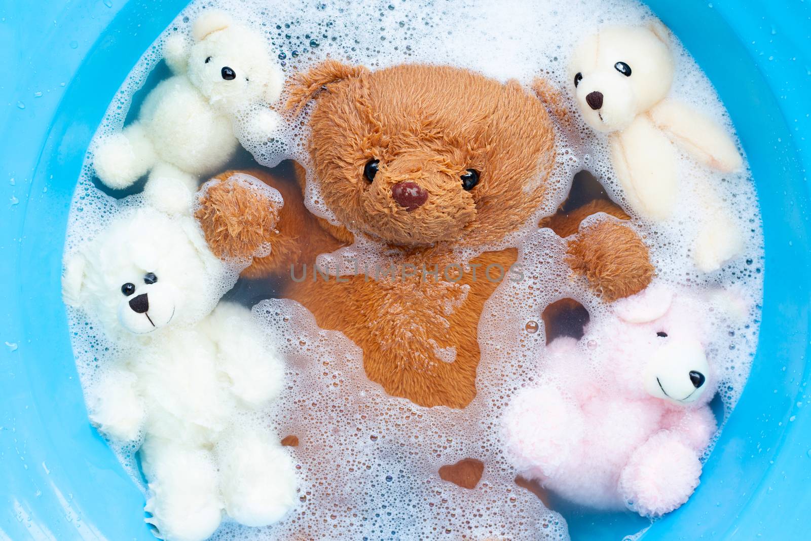 Soak toy bears in laundry detergent water dissolution before was by Bowonpat