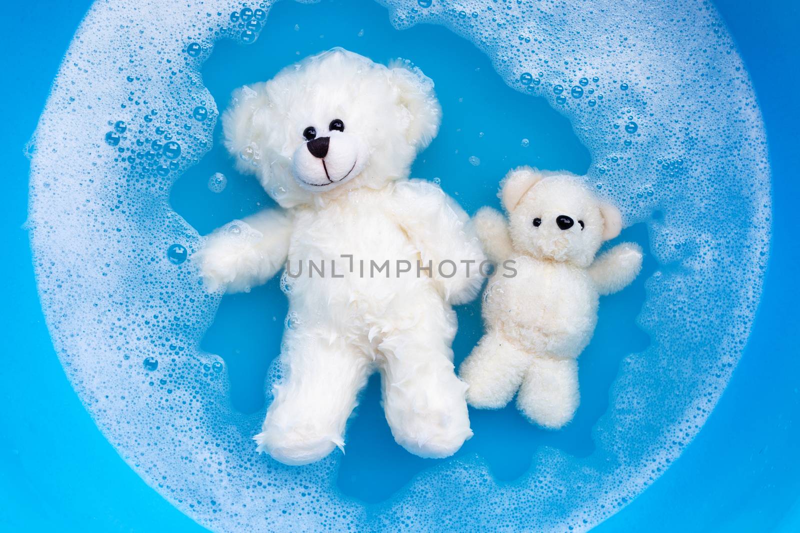 Soak toy bears in laundry detergent water dissolution before was by Bowonpat