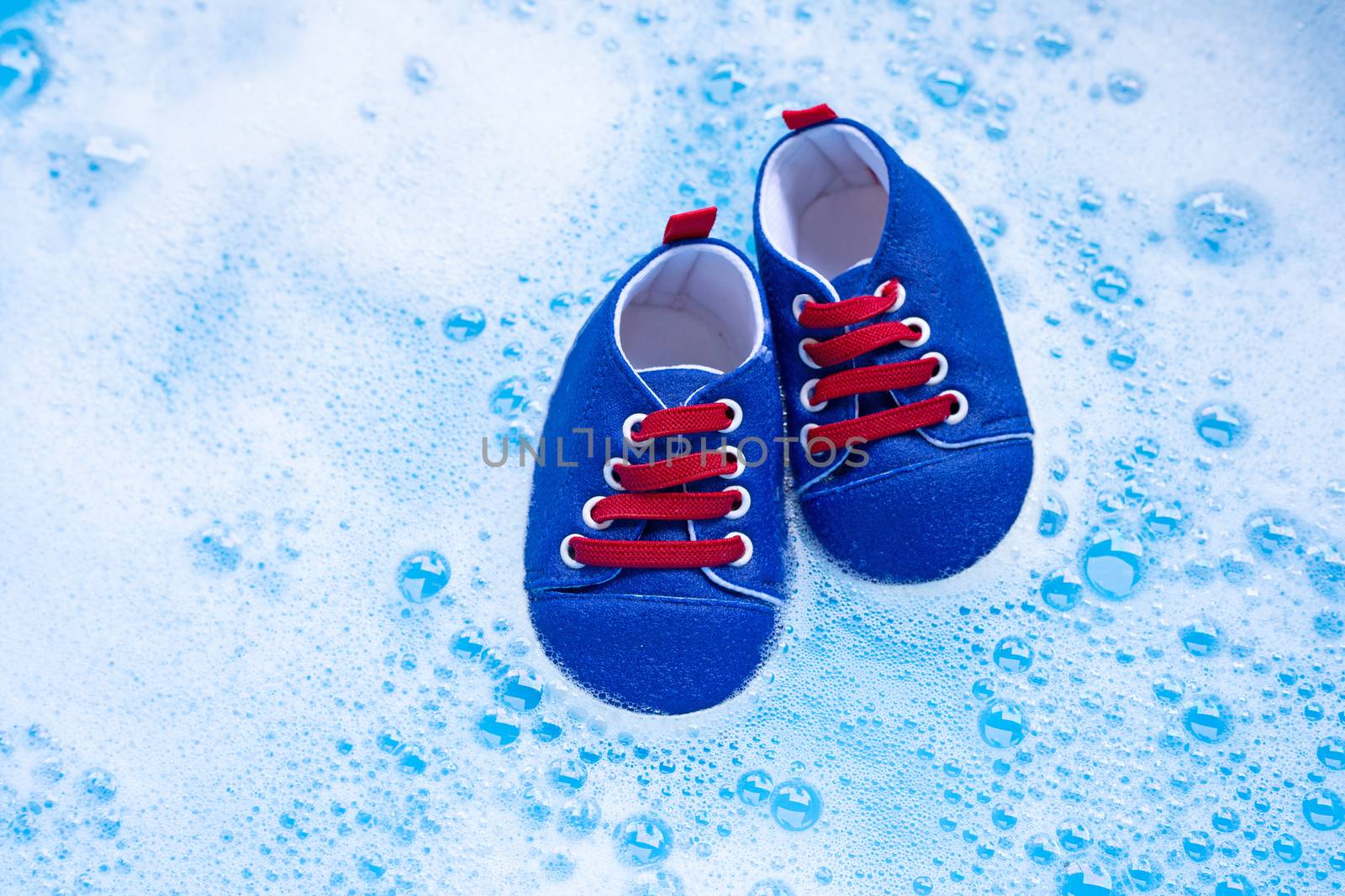Soak baby shoes in baby laundry detergent water dissolution before washing.  Laundry concept, Top view