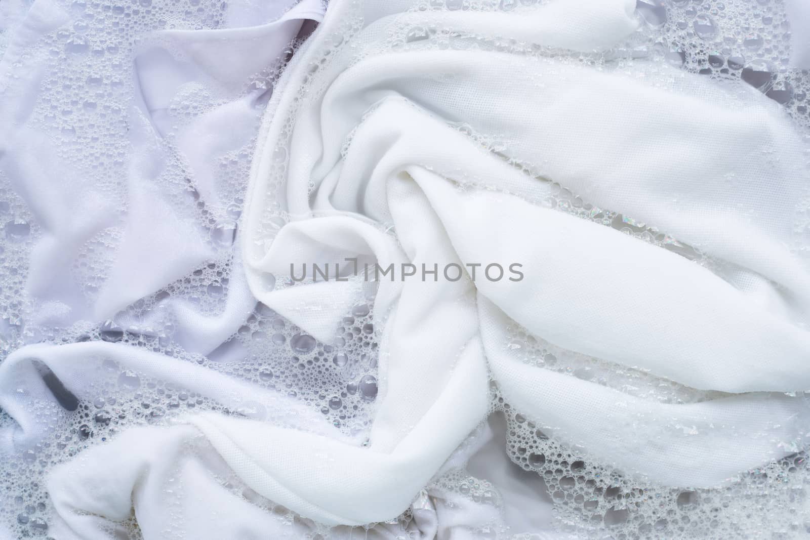 Shirt soak in powder detergent water dissolution. Laundry concep by Bowonpat