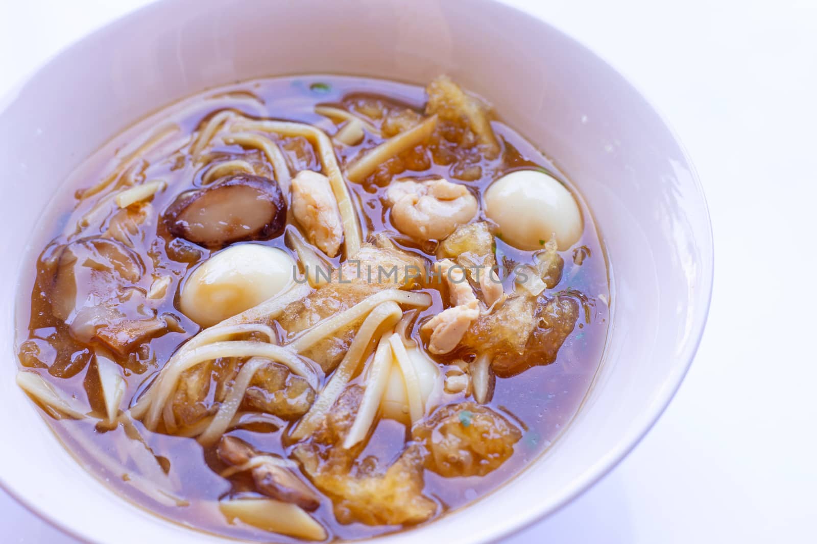 Braised fish maw in red gravy in bowl on white background.