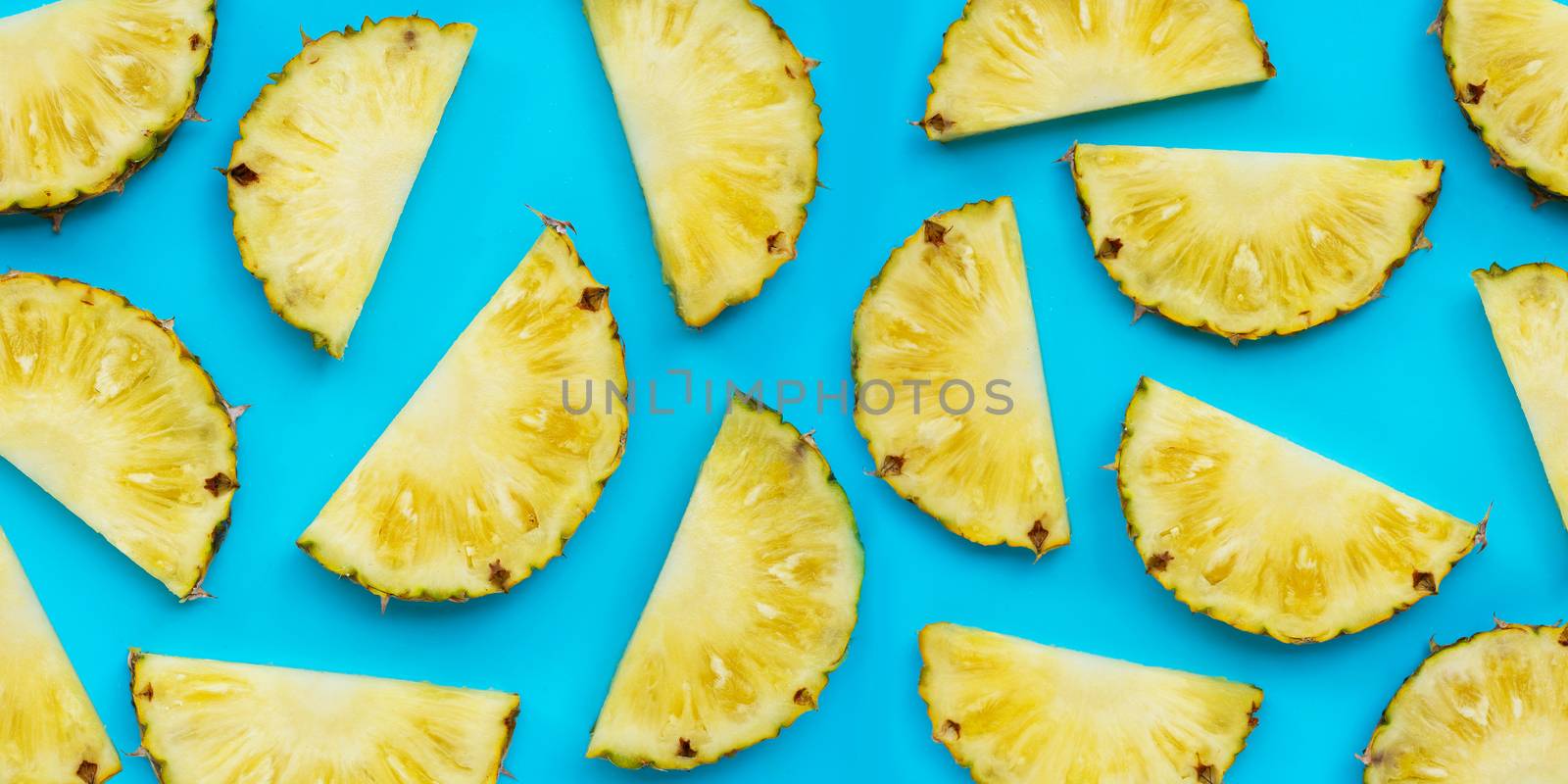 Fresh pineapple slices on blue background. Top view