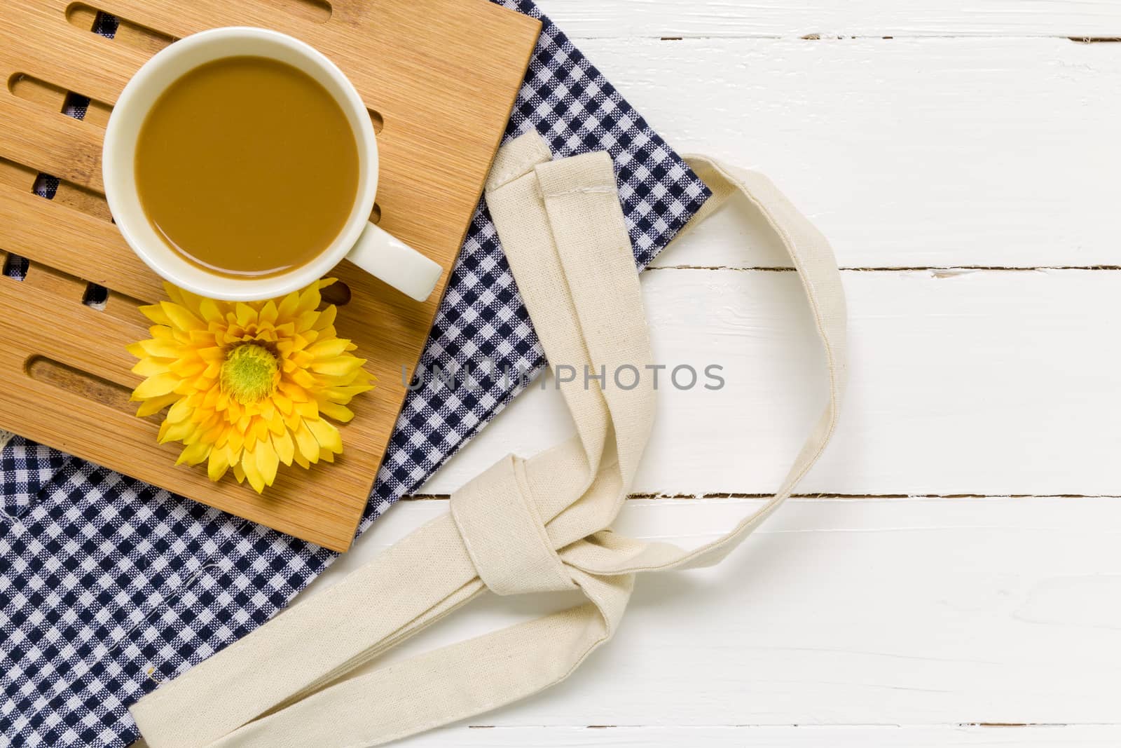 Relaxing break with coffee cup and white wooden background.