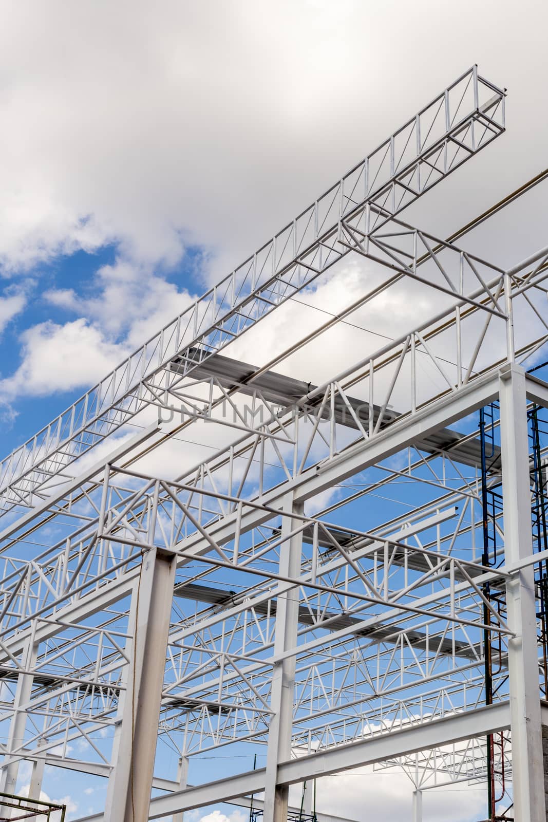Construction of steel frame of big building with blue sky background.