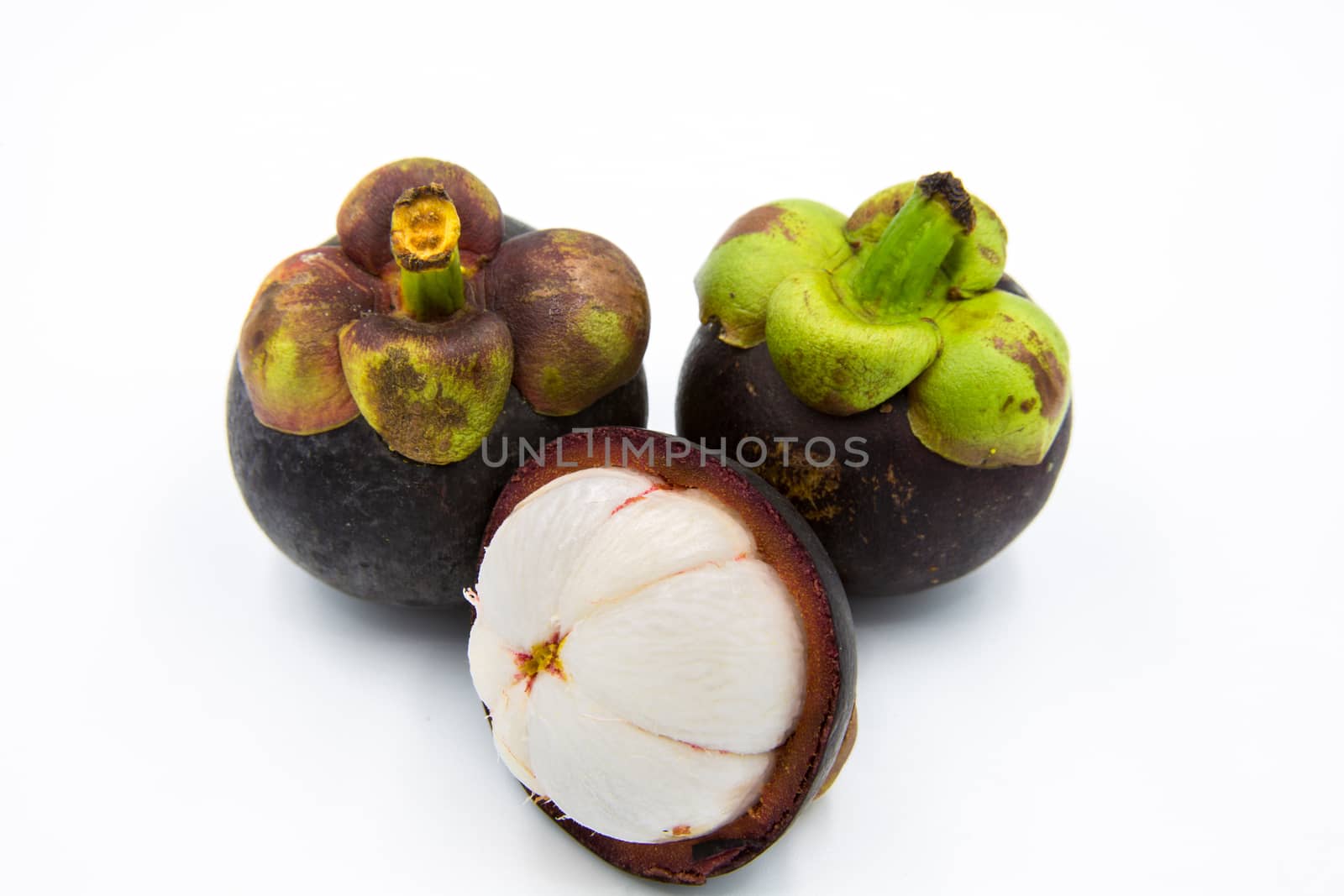 Three mangosteen placed on a white ground.