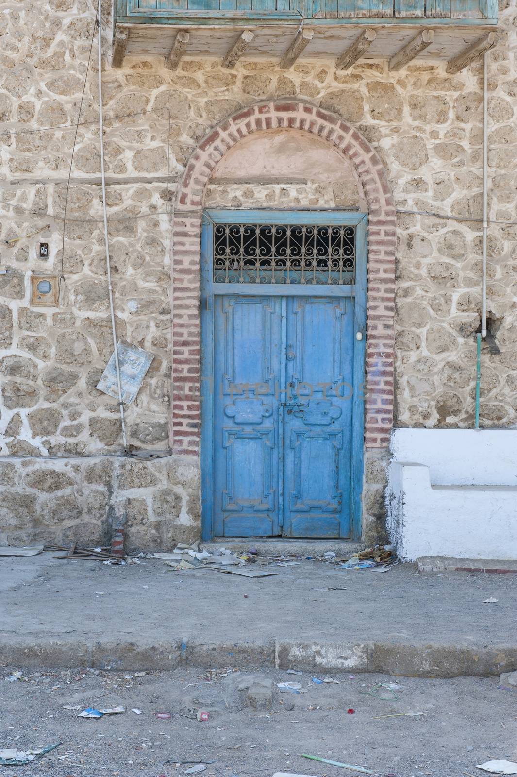 Old rustic door in wall of abandoned traditional egyptian house