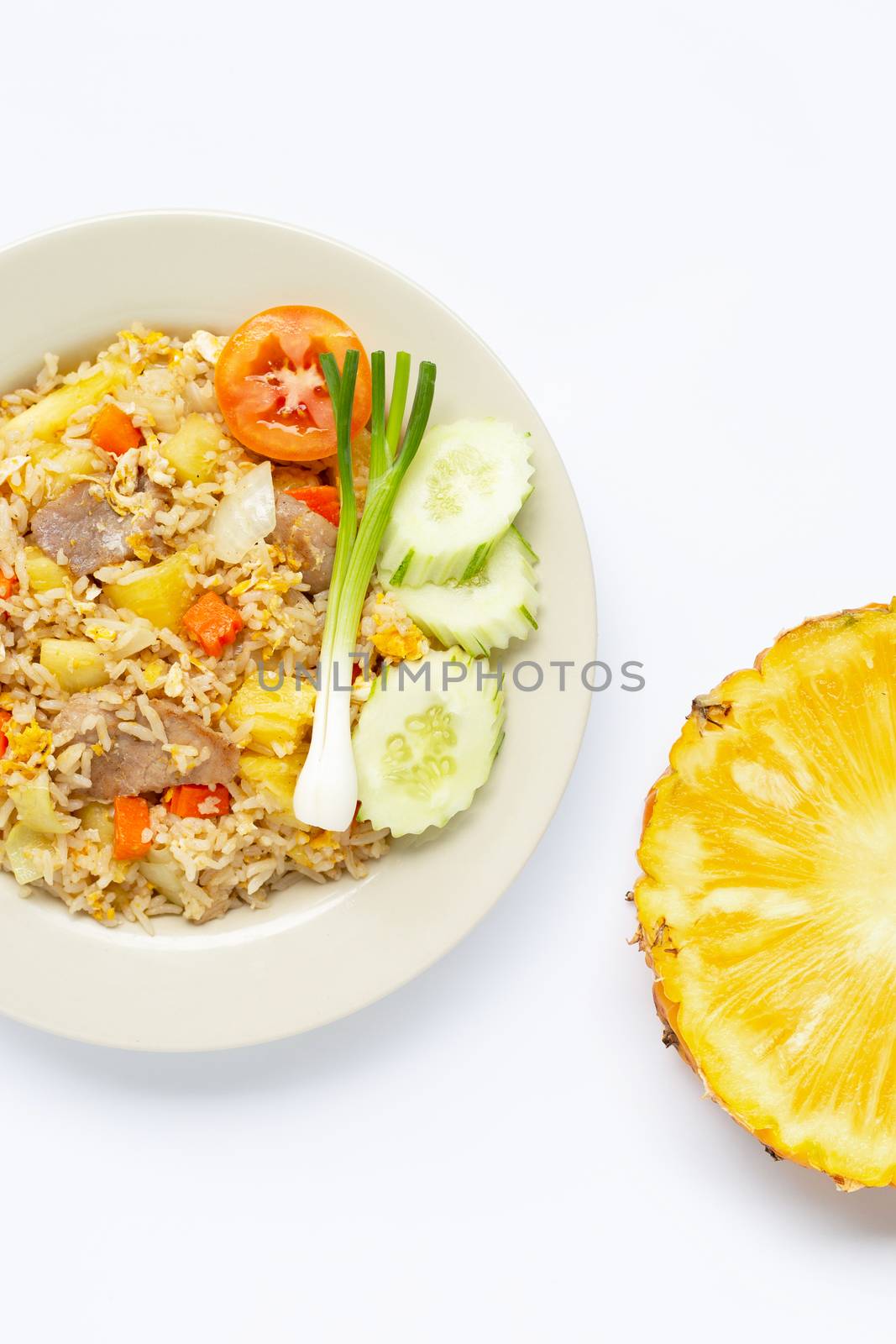 Pineapple fried rice with fresh pineapple slice on white background.