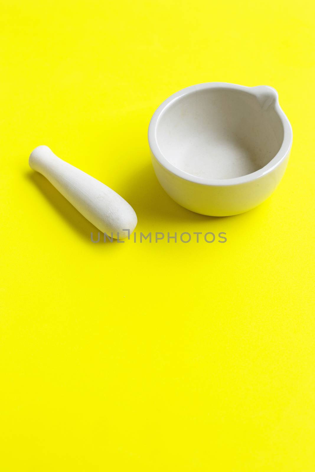 Mortar and pestle on yellow background.  by Bowonpat