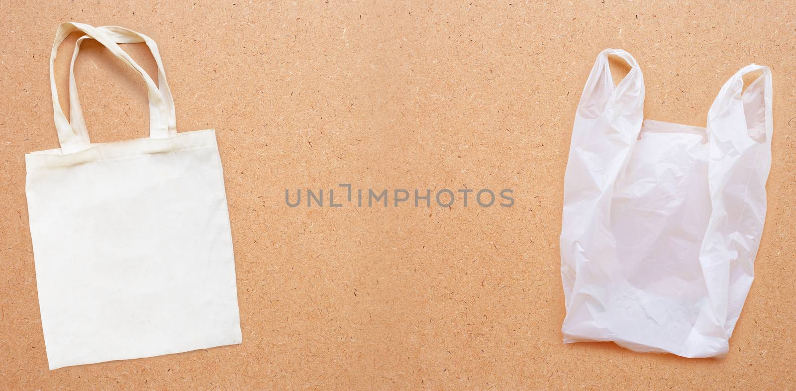 White fabric bag with white plastic bag on plywood background.  Copy space