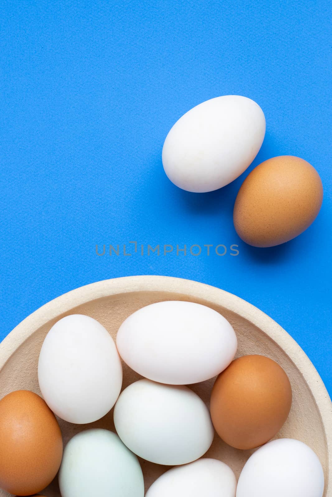Eggs on blue background.  by Bowonpat