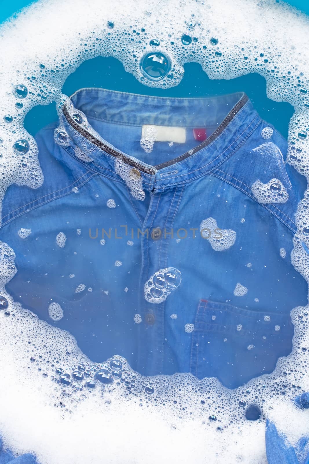 Shirt soak in powder detergent water dissolution. Laundry concep by Bowonpat