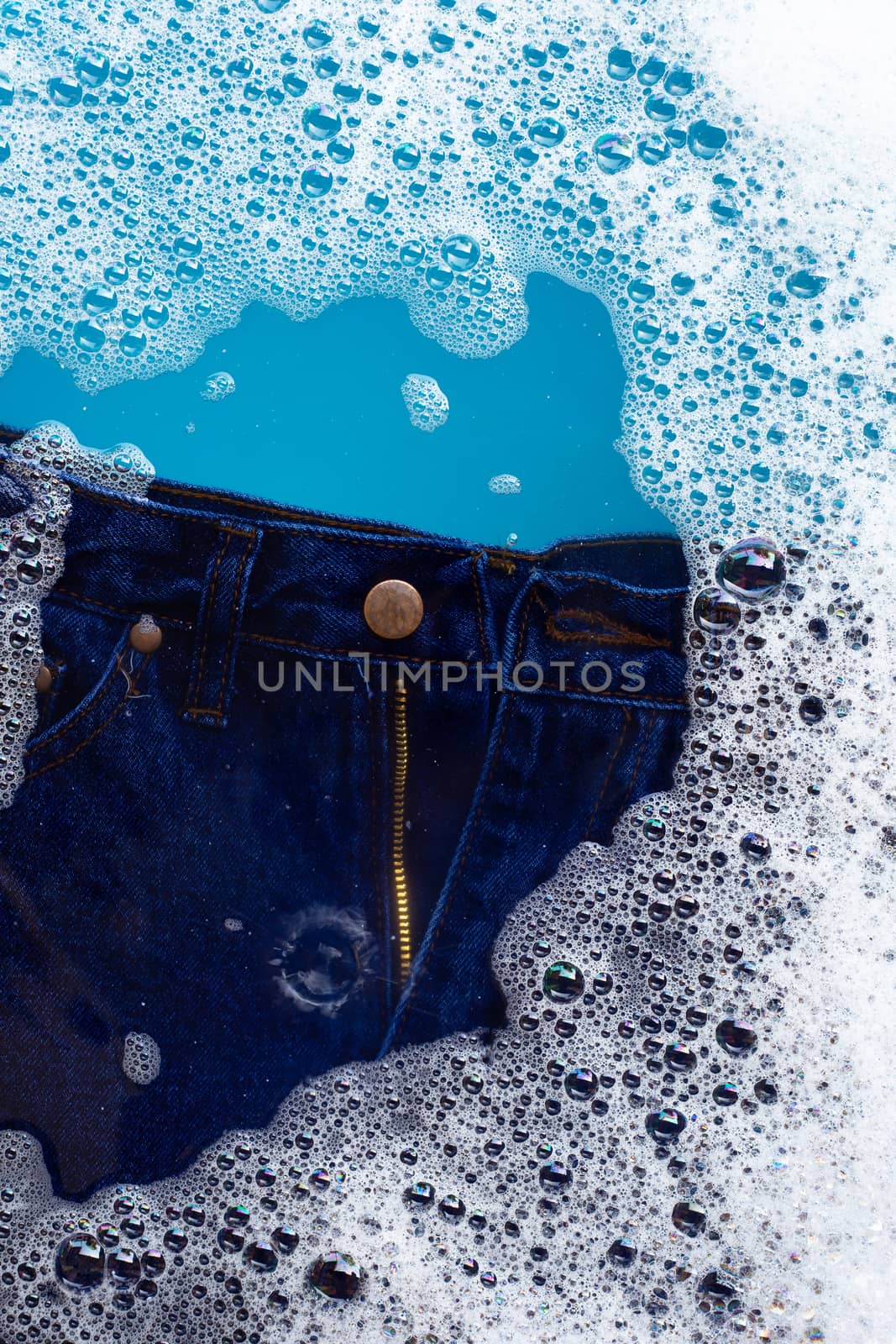 Jeans soak in powder detergent water dissolution. Laundry concep by Bowonpat