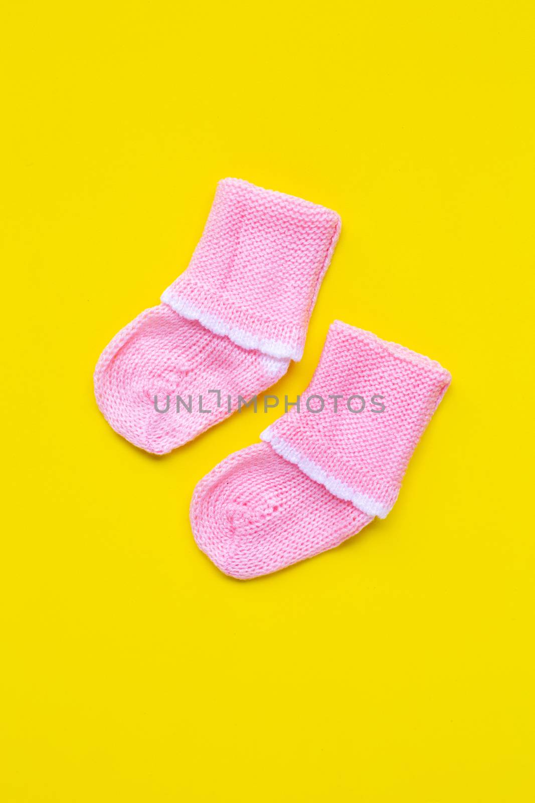 Baby socks on yellow background. Top view
