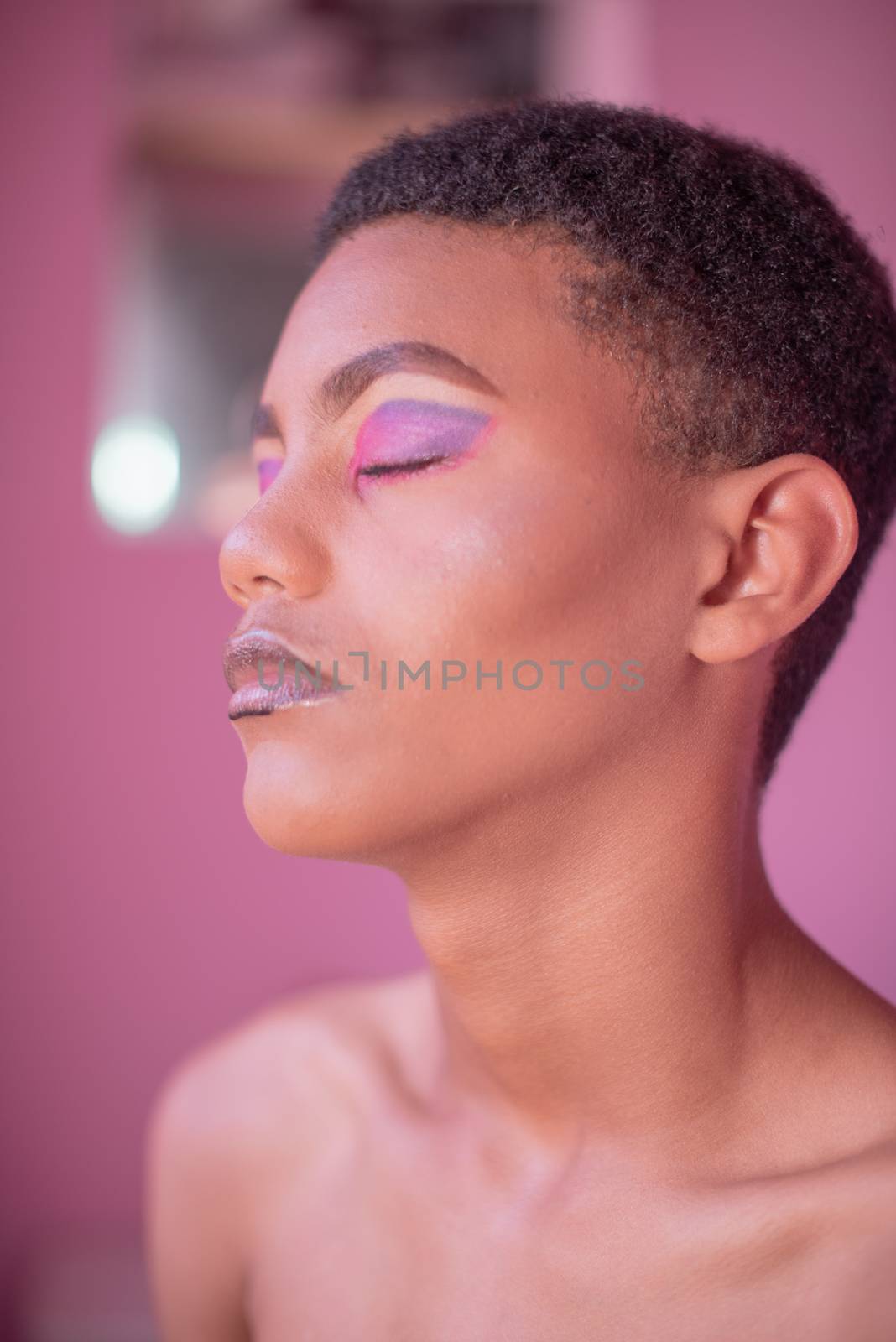Portrait of young queer male with makeup on