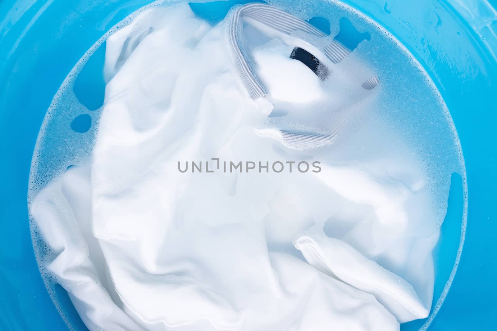 Soak a cloth before washing, white polo shirt. by Bowonpat