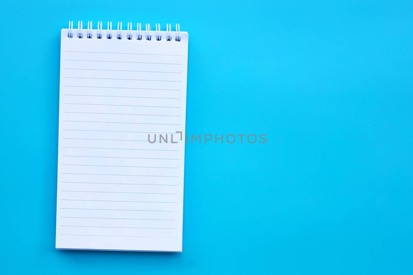 Blank notepad on  blue background.  by Bowonpat