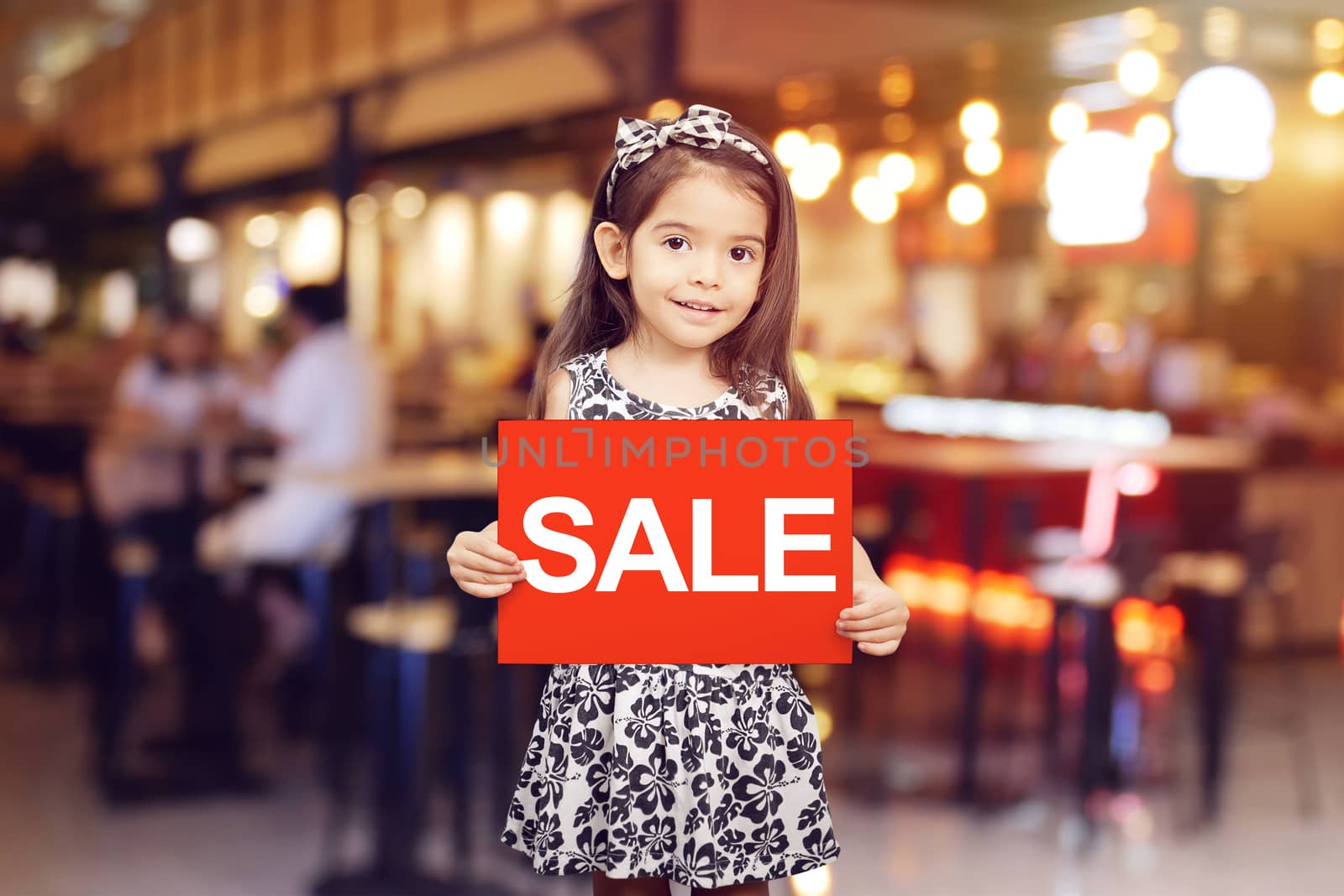 sale discount promotion for shop concept : adorable girl holding red sign with text sale in white color in front of shop , restaurant or cafe by asiandelight