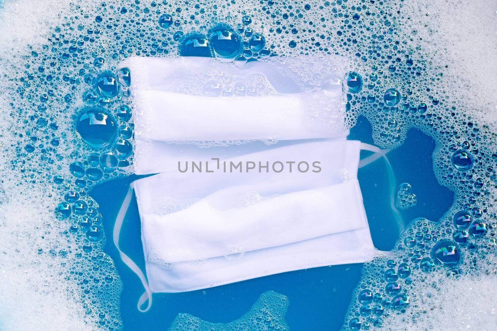 Cloth masks soak in powder detergent water dissolution before washing. Hygiene coronavirus (Covid-19) protection concept