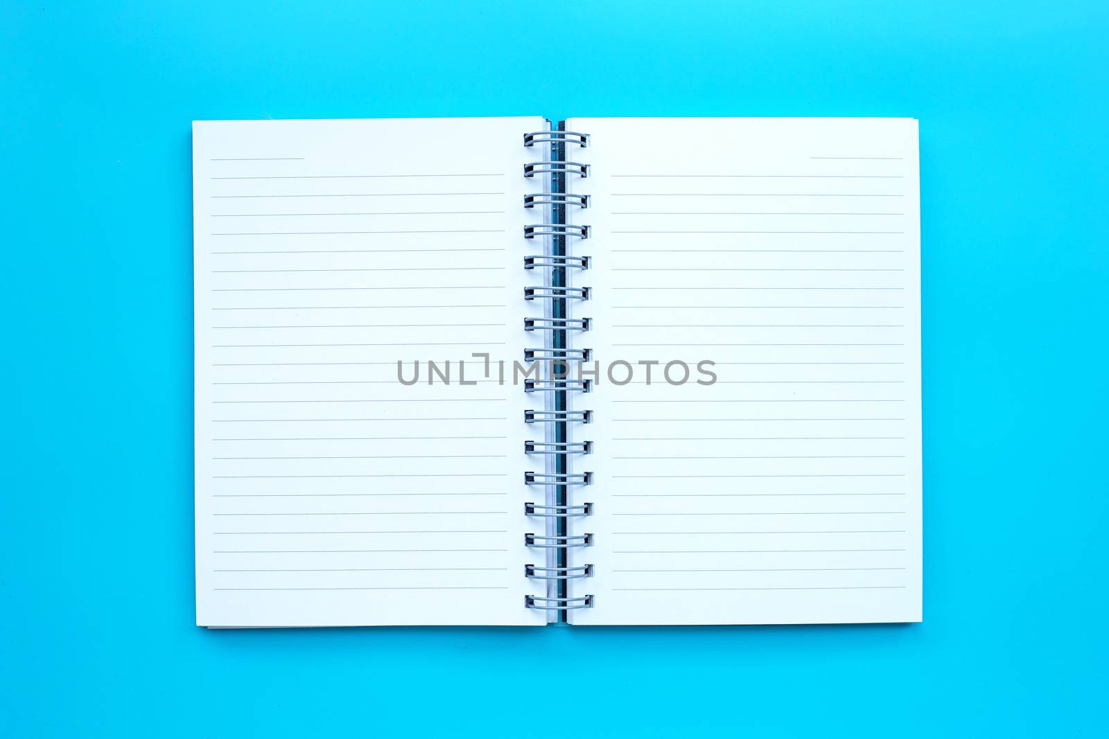 Open diary on blue background. Top view
