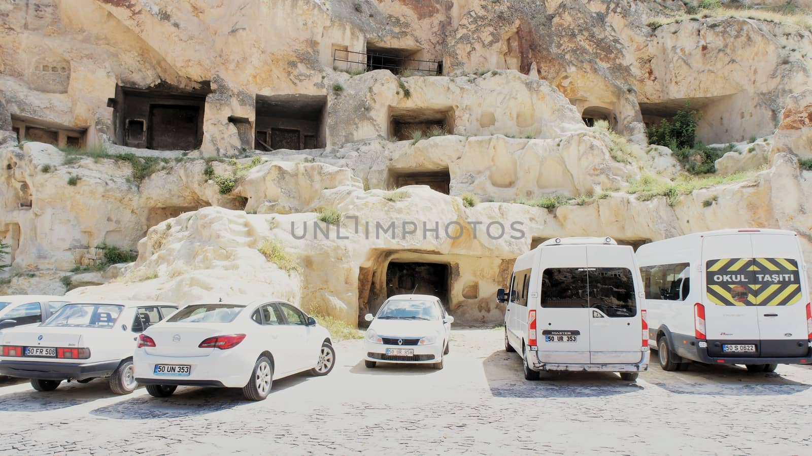 Uegruep, Anatolia, Turkey, July 2nd 2015: Parking in Cappadocia with old former rock flats in the background