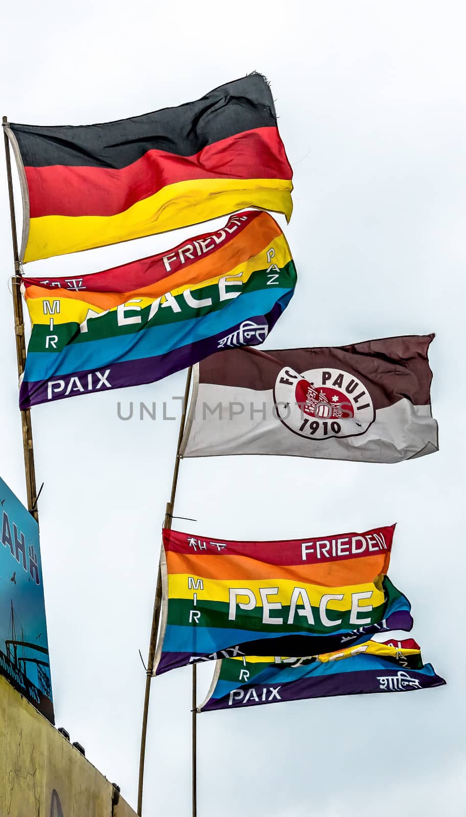 Hamburg, Germany, December 10th 2017: Flags of the soccer club FC St. Pauli and the colorful peace flag blow in the wind at the harbour.