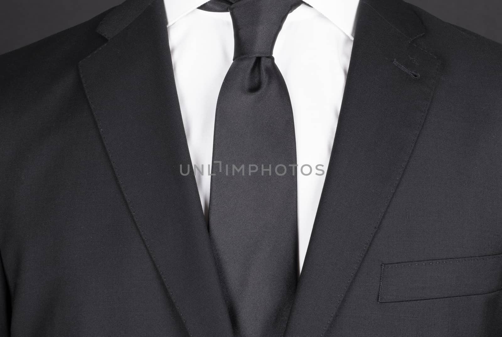 Man in a black suit with black tie, close-up