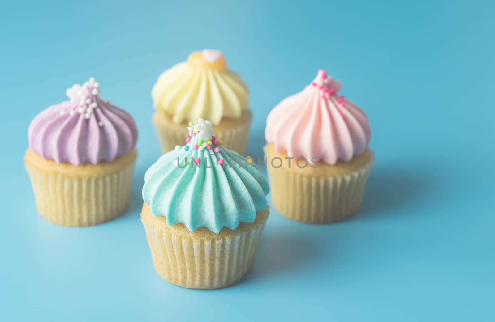 Colorful Pastel Cupcake on blue pastel background with blue cupcake on focus by junce