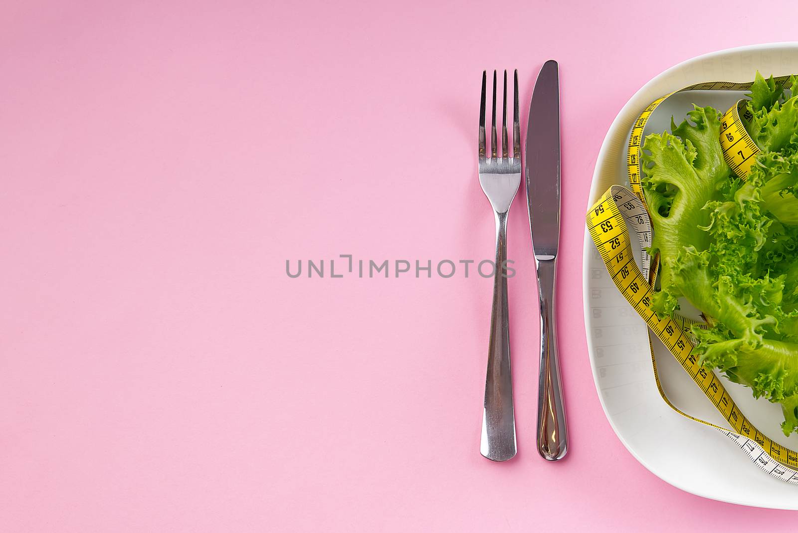 Bunch of vegetables isolated on pink background. salad tape weight. Pile of fresh vegetables with measuring tape. Green vegetable smoothie