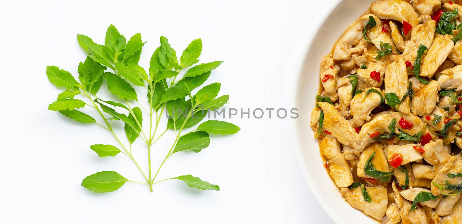Holy basil leaves and dish of stir-fried chicken with holy basil by Bowonpat