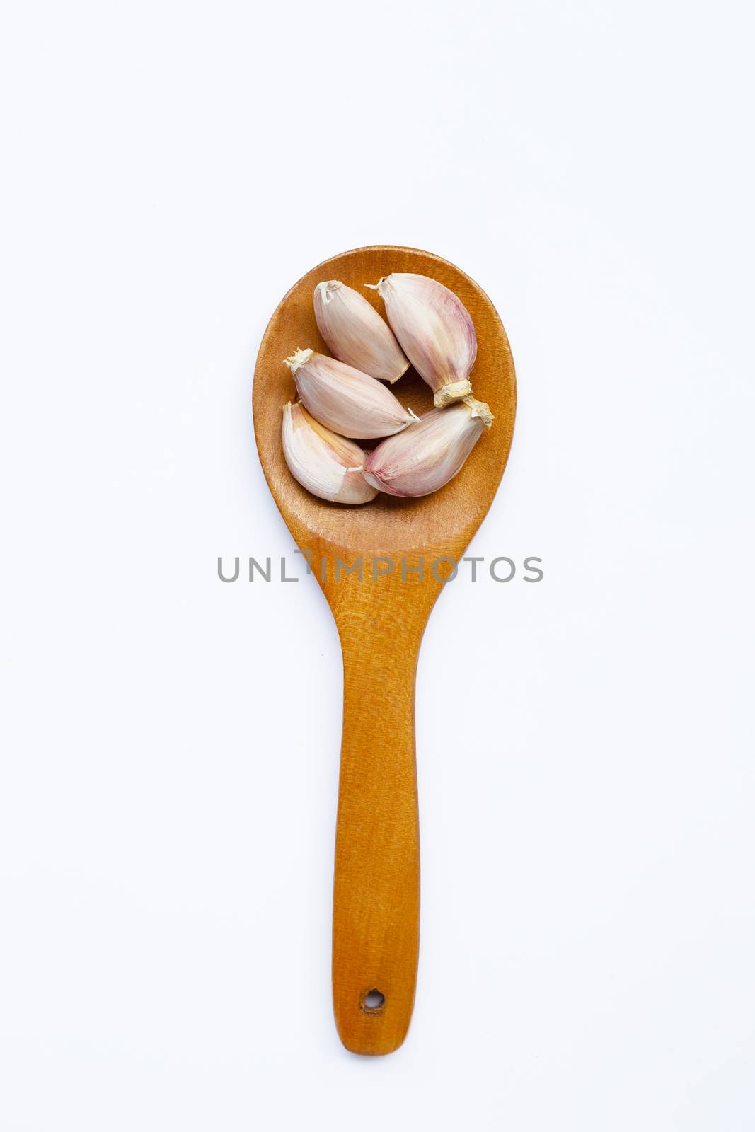 Garlic on wooden spoon on white background. 