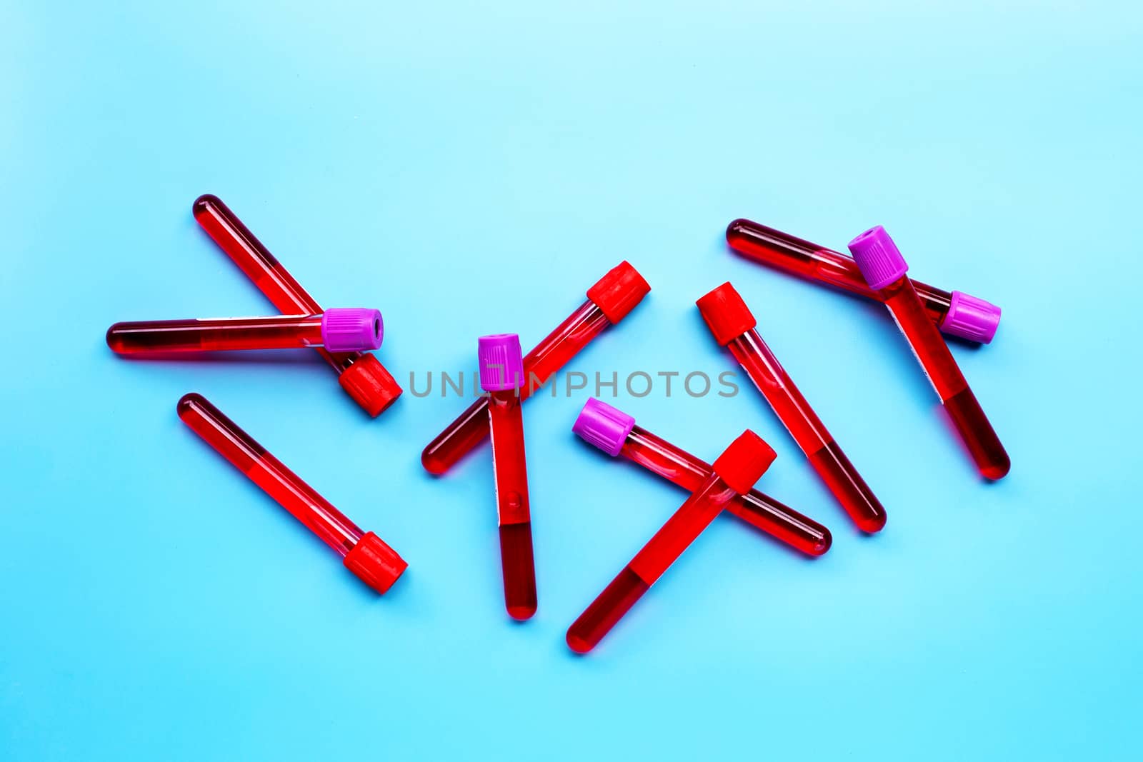 Blood in test tubes on blue background. Top view