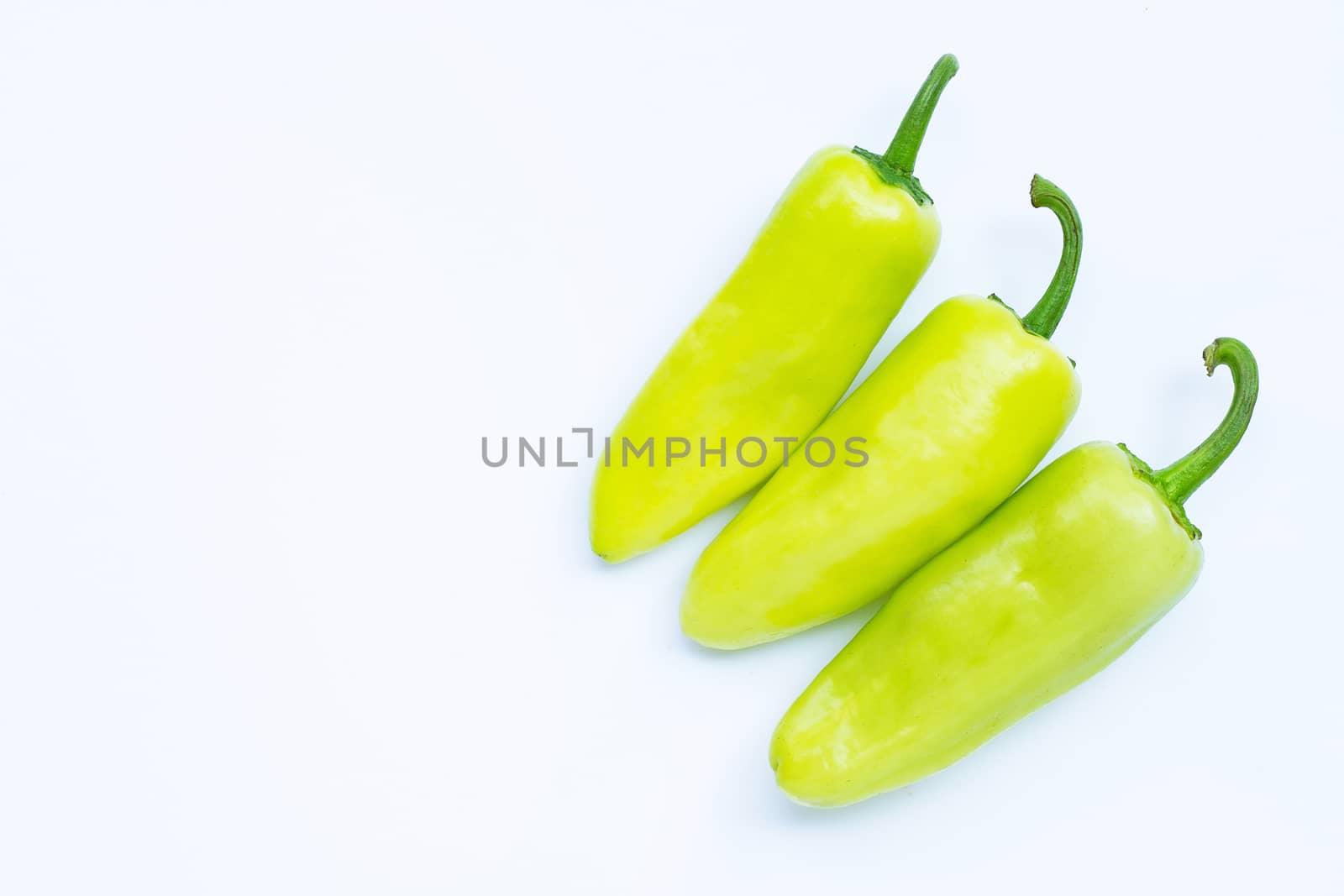 Green hot peppers on a white background.