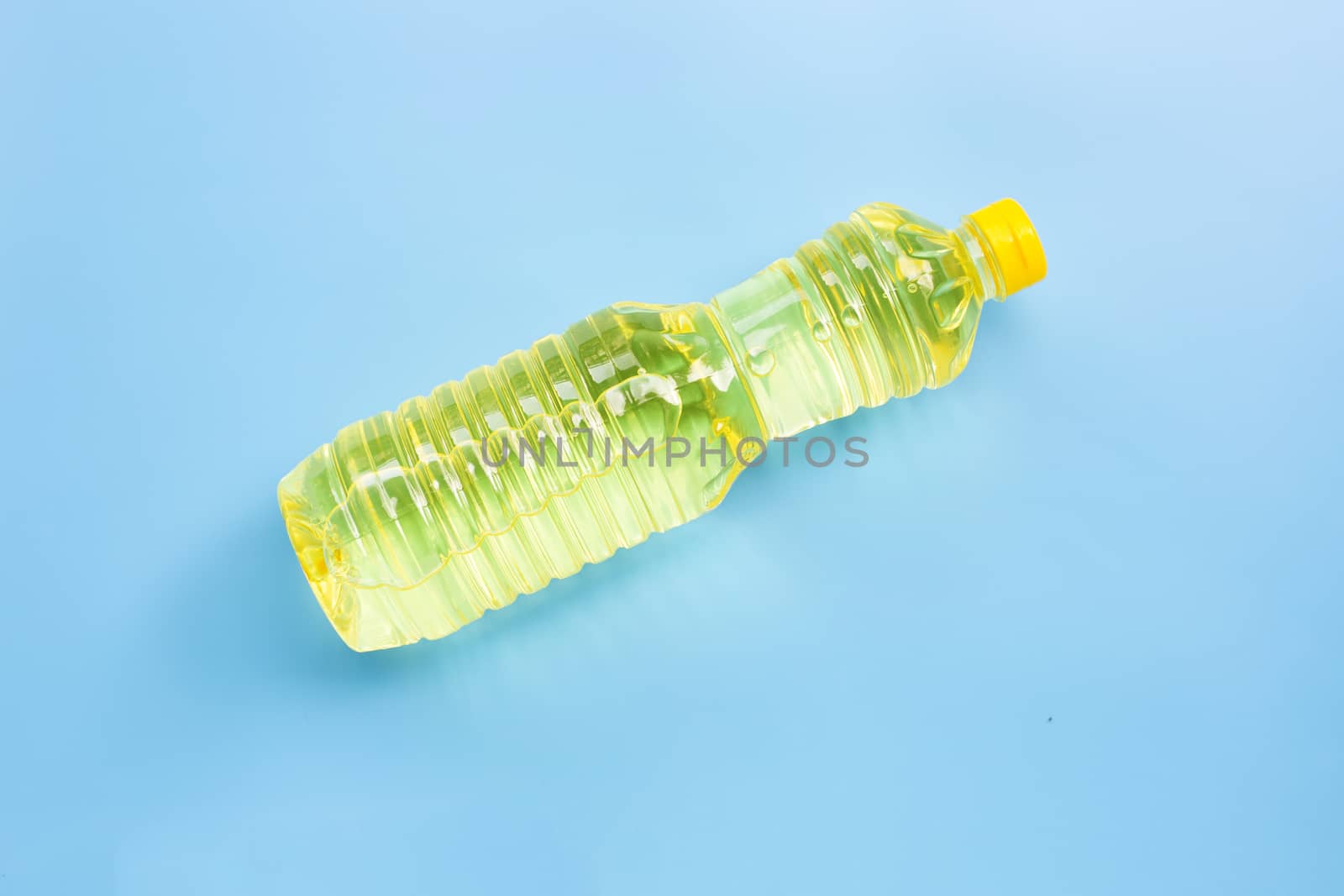 Oil in plastic bottle on blue background. Copy space