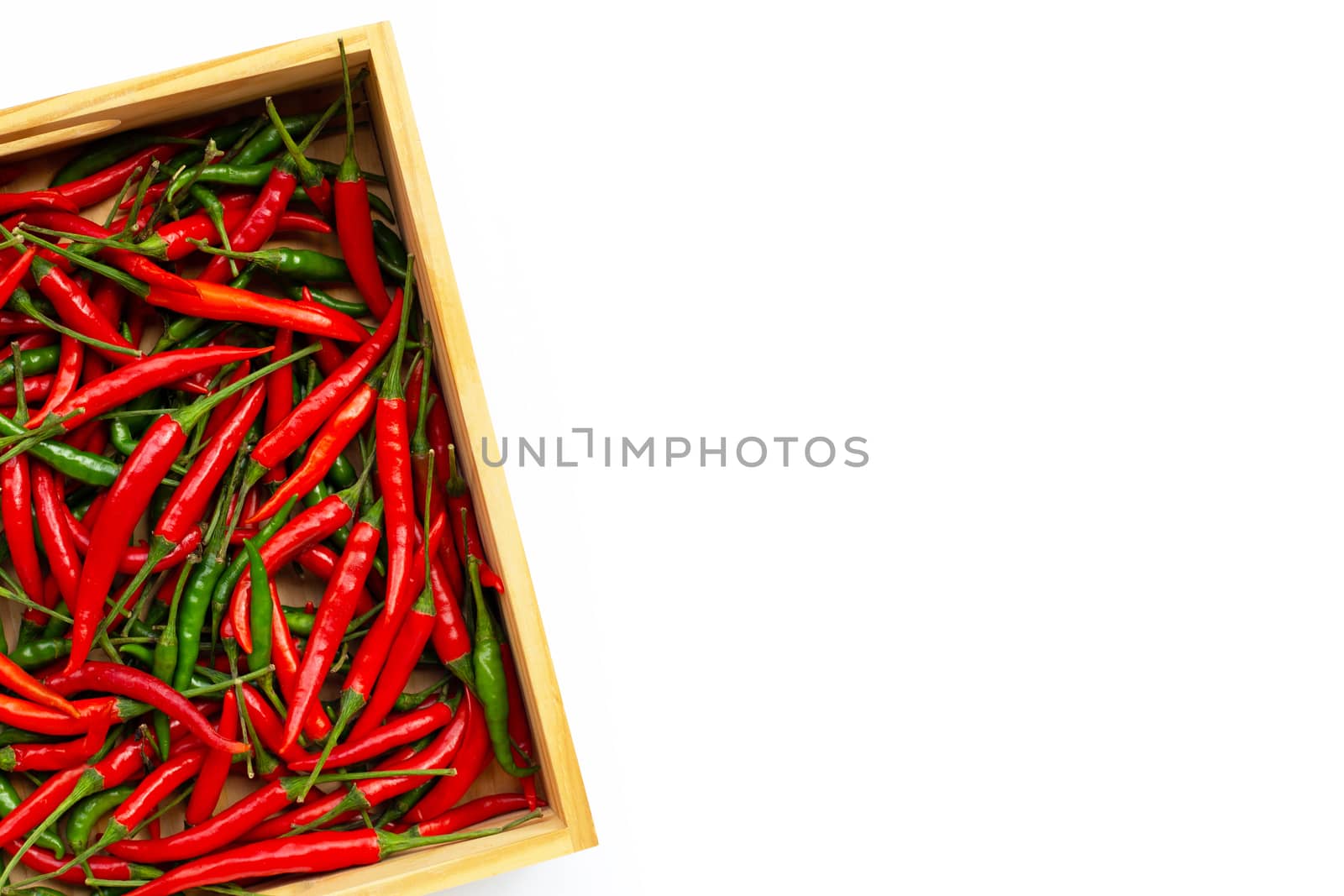 Hot chili peppers in wooden box on white background. Copy space