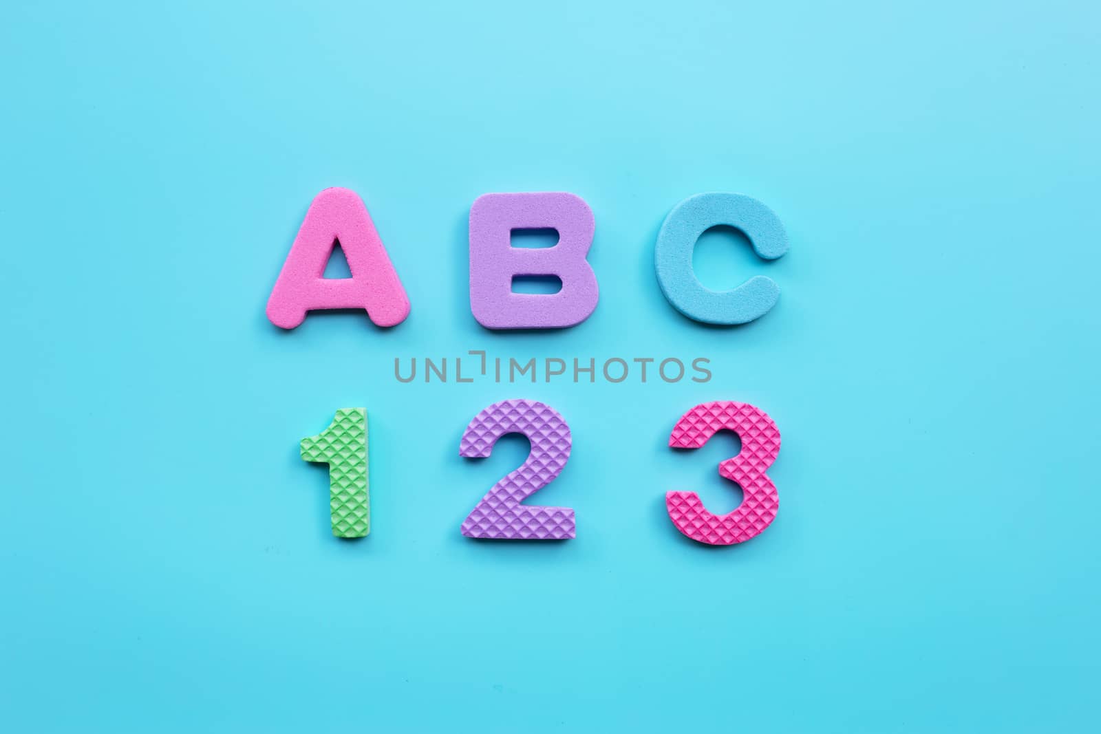 English alphabet and numerals on blue background. Education concept, Copy space