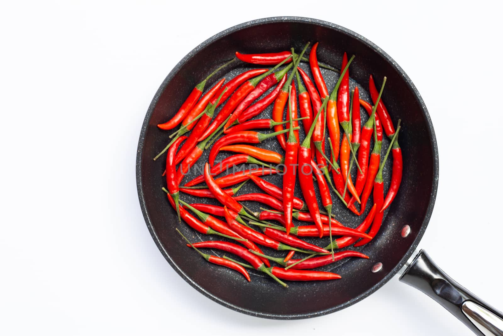 Hot chili peppers in a pan on white background. Top view