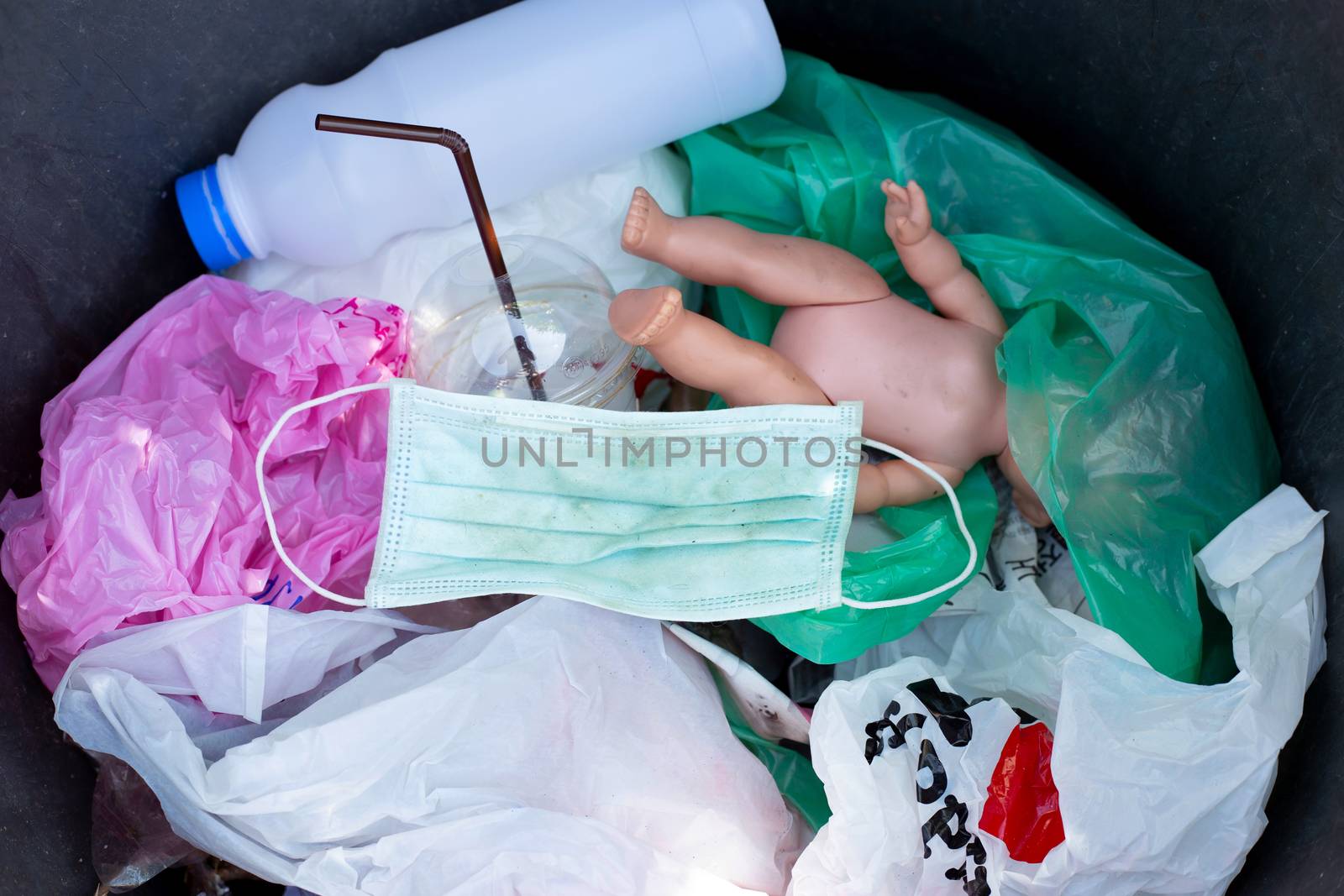 Dirty used surgical mask in a garbage bin.