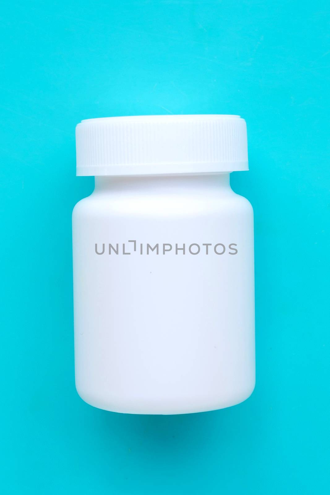 Blank white medicine bottle on blue background. Top view