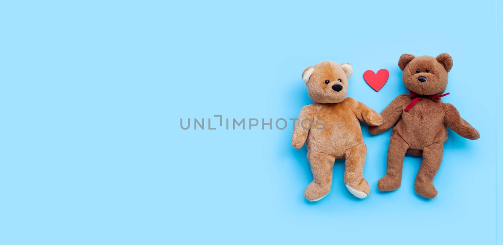 Bear toy couple with heart on blue background. by Bowonpat